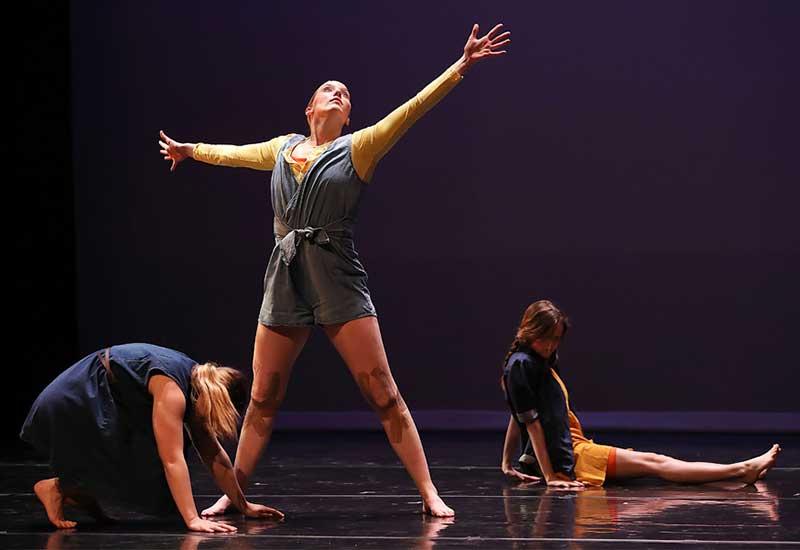 three student performers give a dance recital